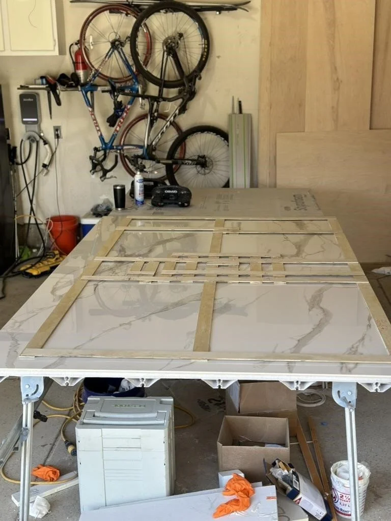A shower wall template laid on a gauged porcelain panel ready to be cut to the template. Details in the middle indicate location of the body sprays and diverter.