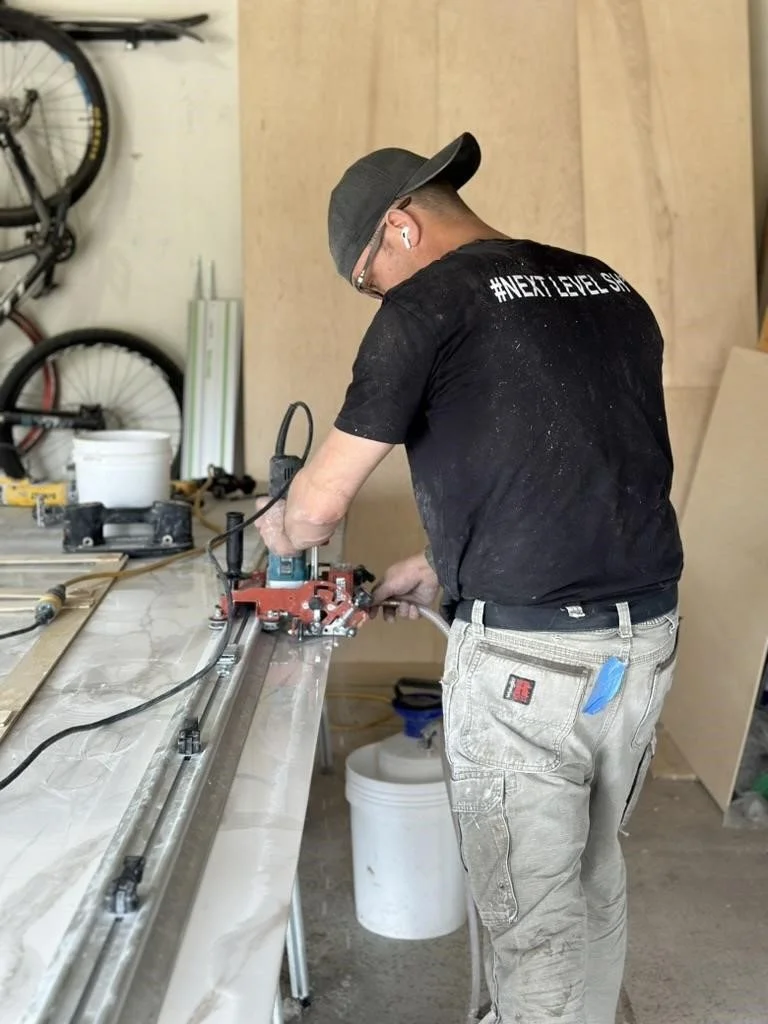 Adam uses a wet handsaw to cut his templated line for a panel destined for the shower.