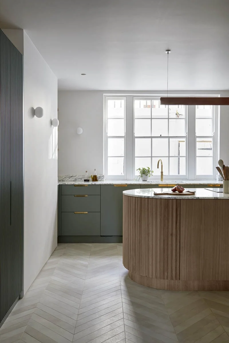 London-based interior design studio Indie & Co h as created an on-trend kitchen island with a fluted wood base and a veined marble worktop. Kitchen: West & Reid . Photograph y: Anna Stathaki.