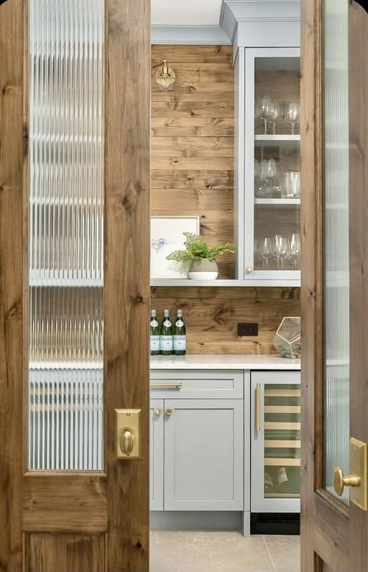 Rippled glass doors distort the eye into the pantry but don’t hide its beauty. Design via Plain and Posh