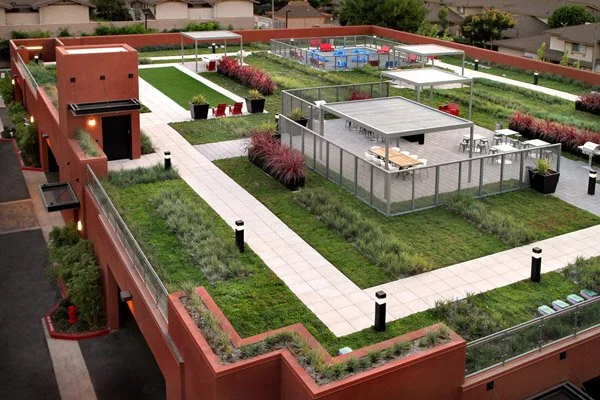 Rooftop garden with pathways, seating areas, and enclosed sports courts.
