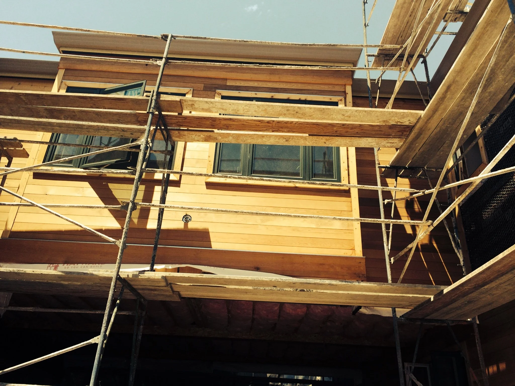 Construction site with wooden framing and metal scaffolding of a building under construction.