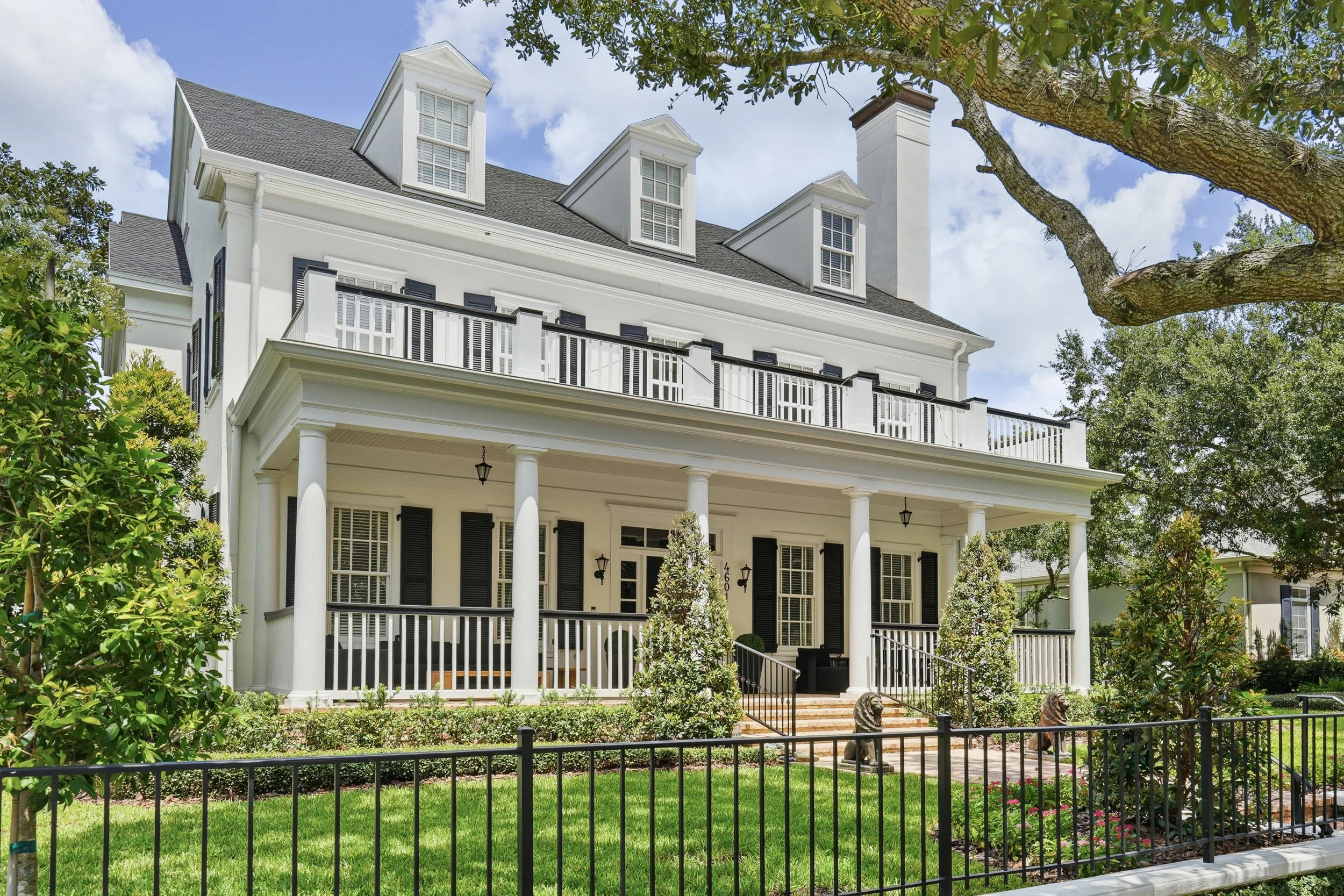  An inviting approach highlights stately columns, brick entry steps, traditional shutters and generous outdoor living spaces spanning both levels. 