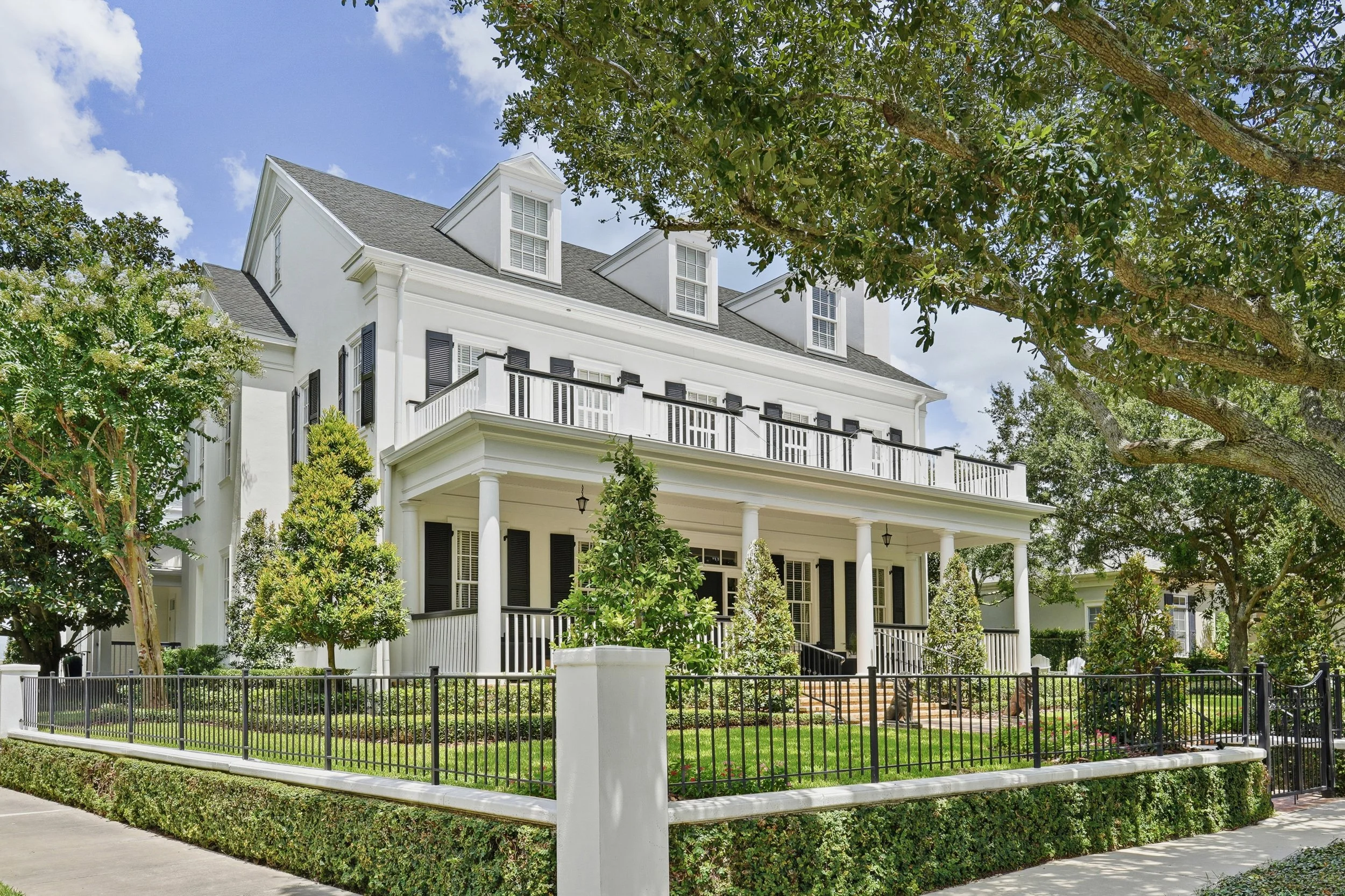   A commanding corner presence surrounded by mature trees and manicured grounds, showcasing the home’s classic architecture, expansive porches and beautifully landscaped setting. 