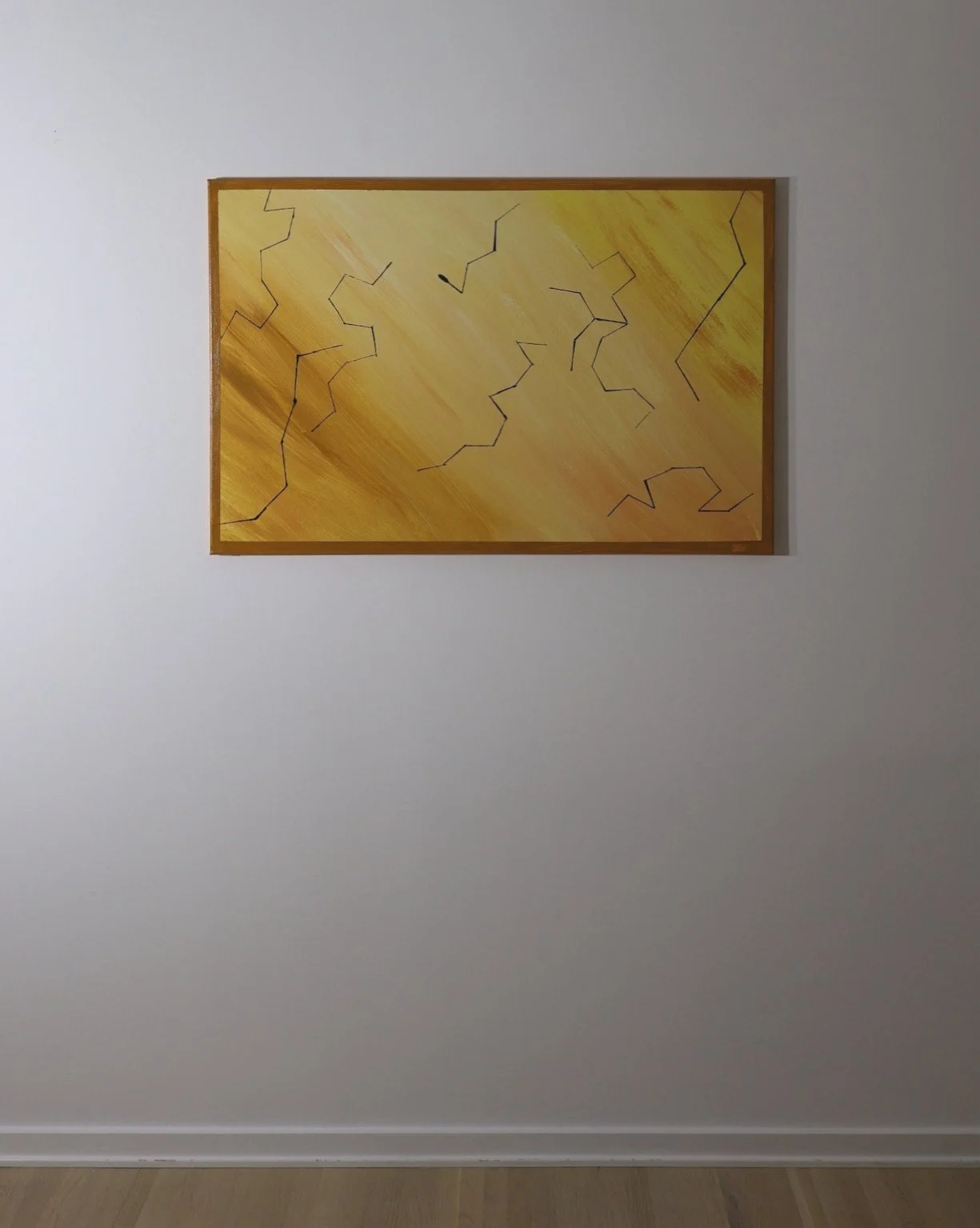 Abstract yellow and orange painting with black lines on a white wall.