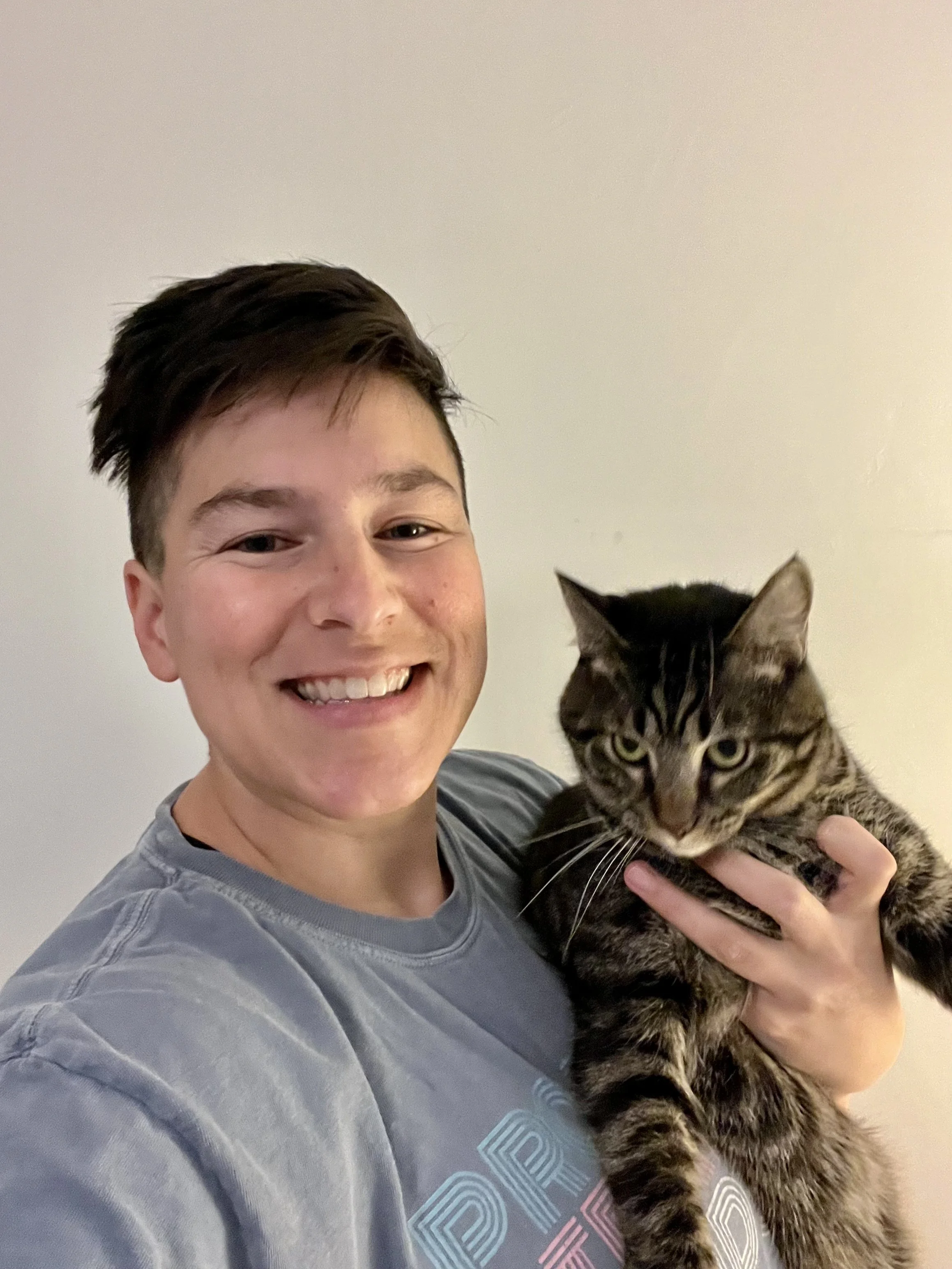 Sarah smiling and holding a tabby cat