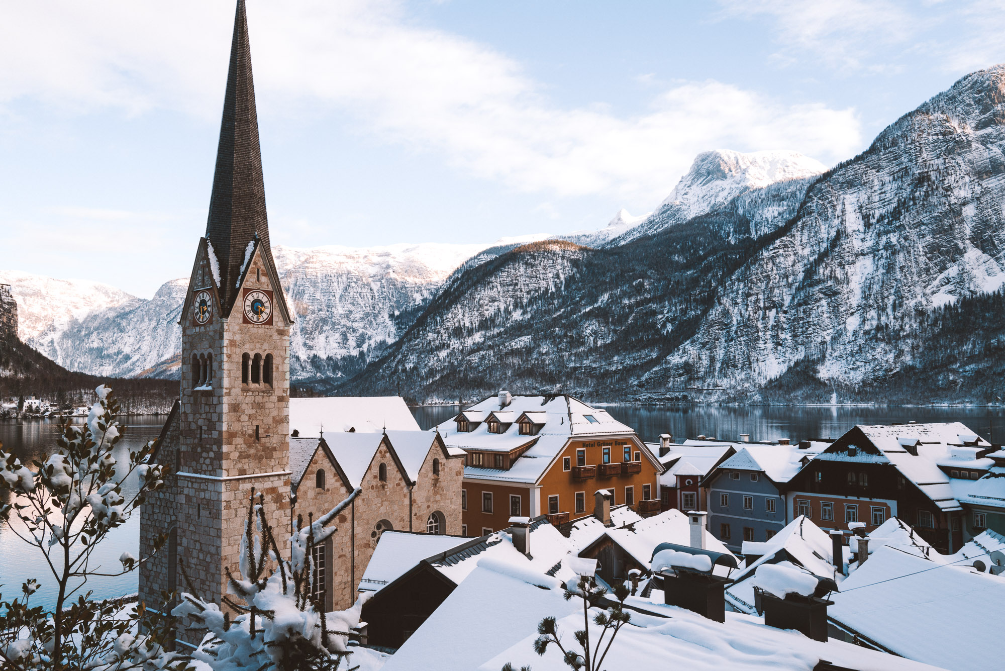 A church in the town of Hallstatt during the winter months, snowy mountains are seen in the back