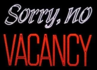 A sign with the words "Sorry, NO VACANCY" written in neon lights, "Sorry, NO" in white and "VACANCY" in red.