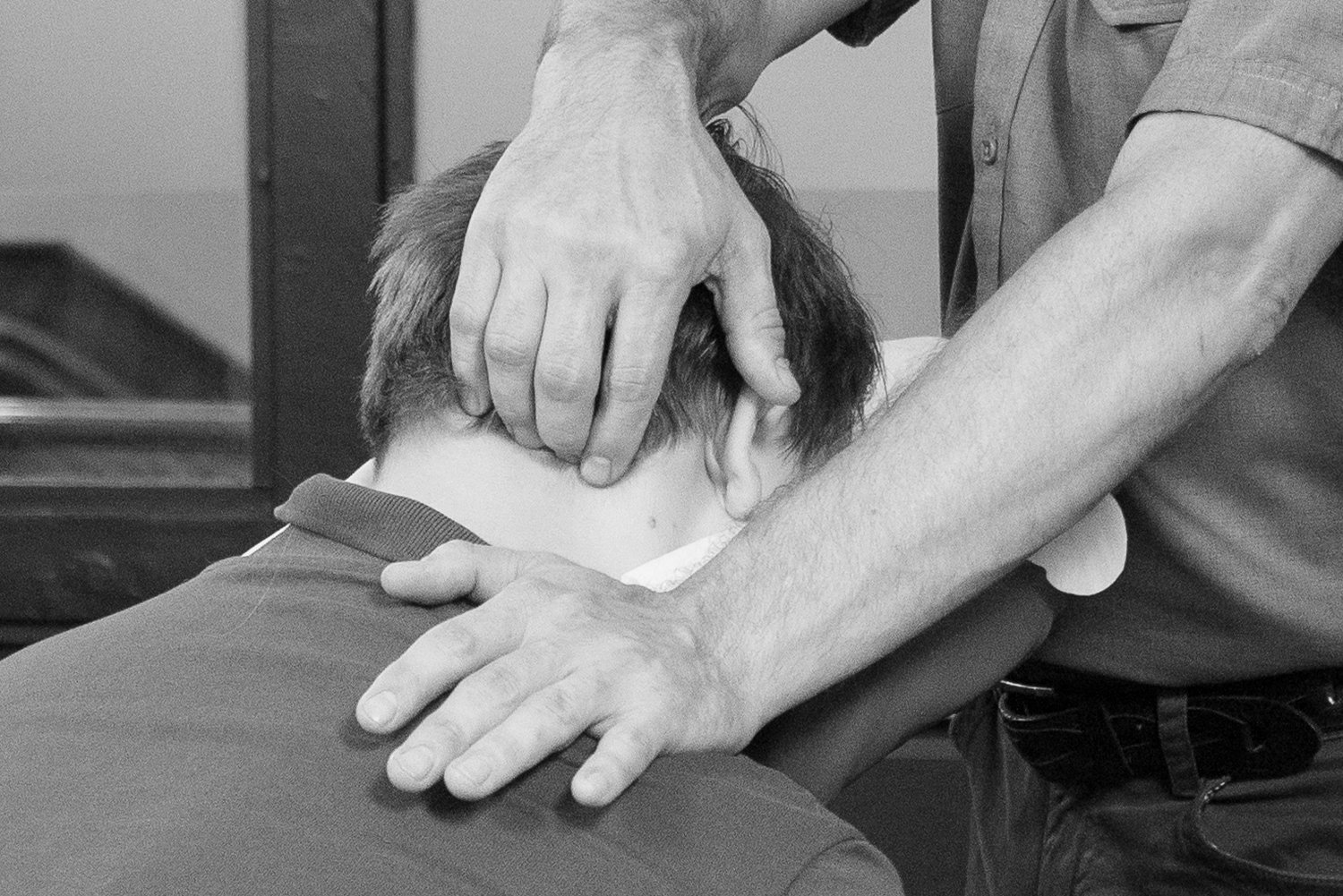  deep pressure seated massage being administered to someone’s neck and shoulders at The Backstop in Northampton, MA 