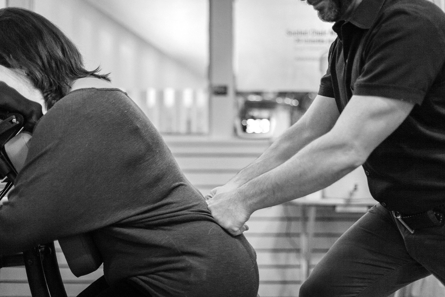  woman receiving a refreshing seated massage on her lower back  