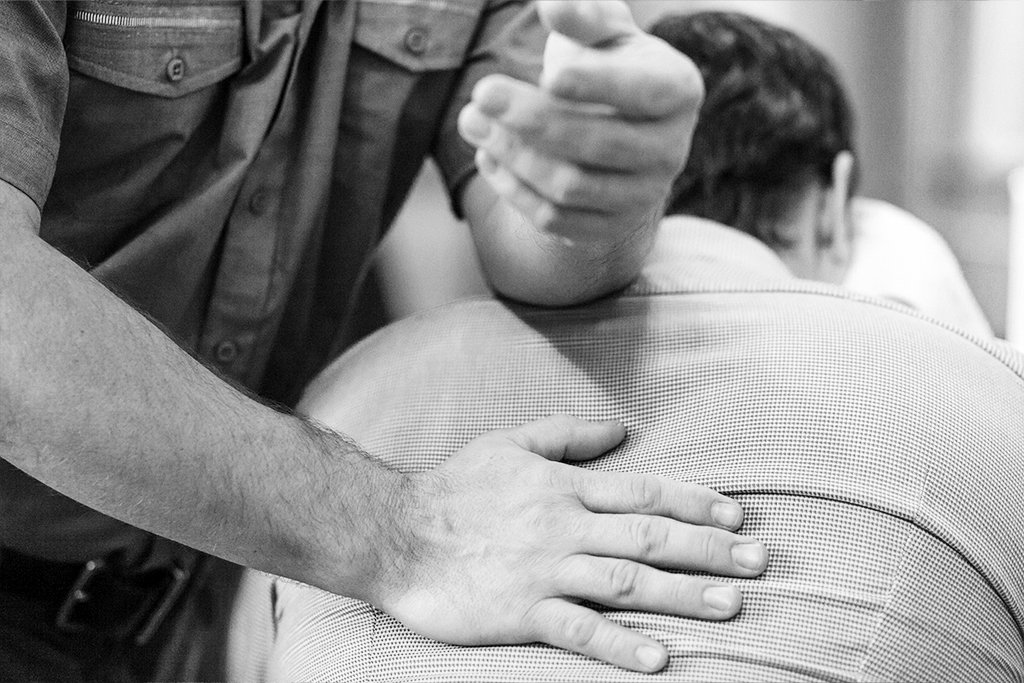  a therapist providing a shoulder and back massage to a man during a seated massage at the backstop 