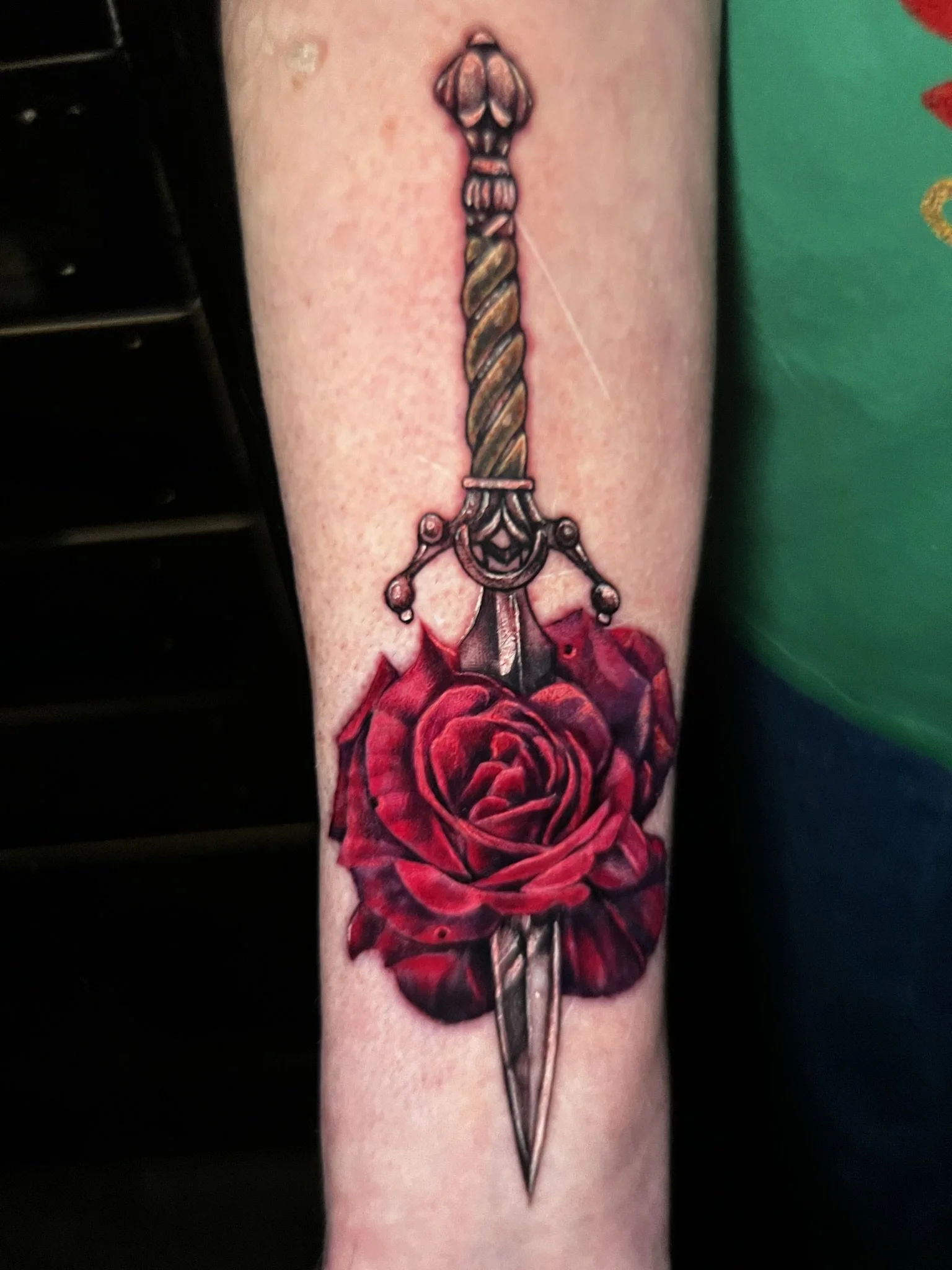 full color saturateion rose and dagger done on the arm by sterling gorejus done at east tiger tattoo studio in merrillville indiana