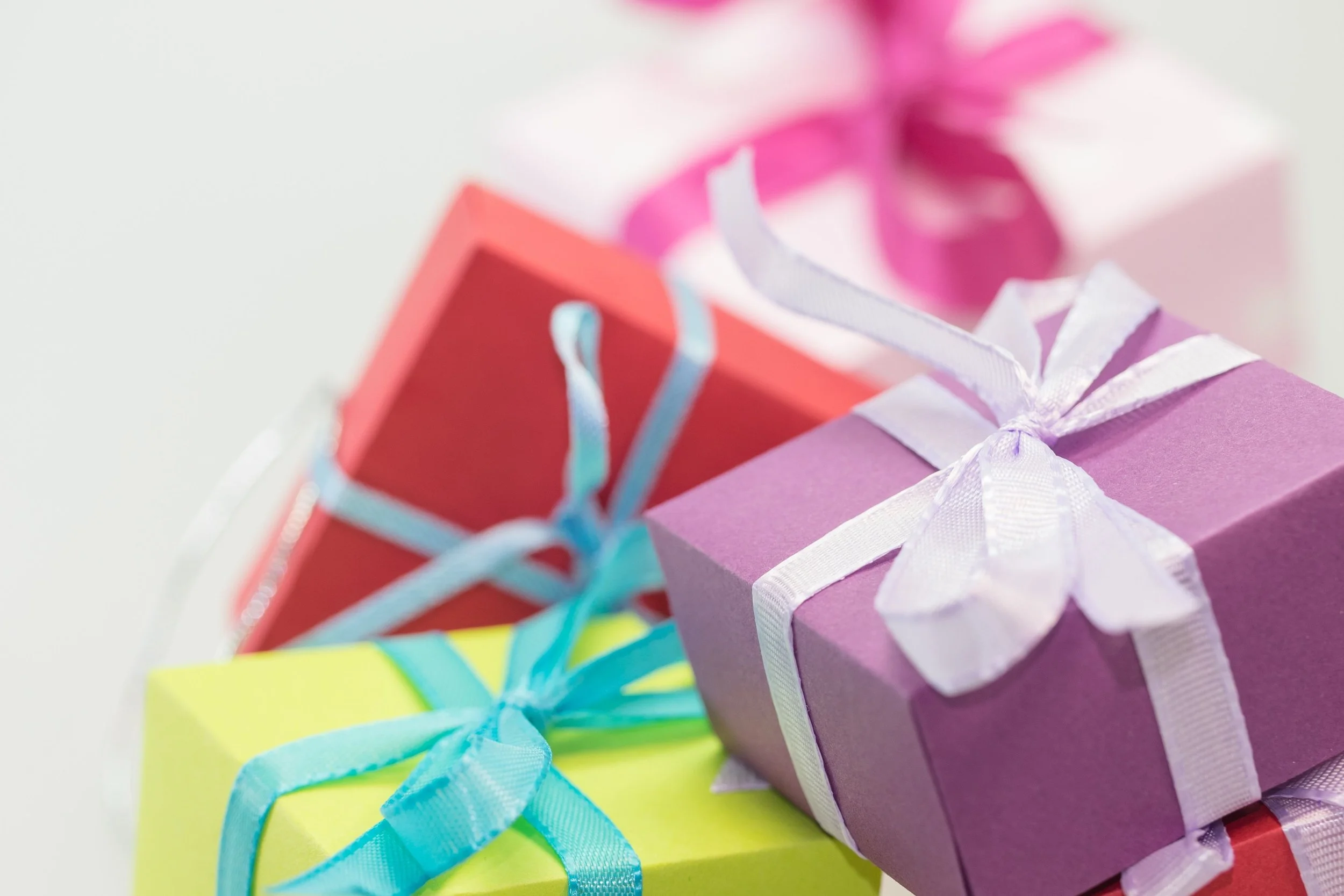 Colorful gift boxes wrapped with ribbons, stacked on top of each other.