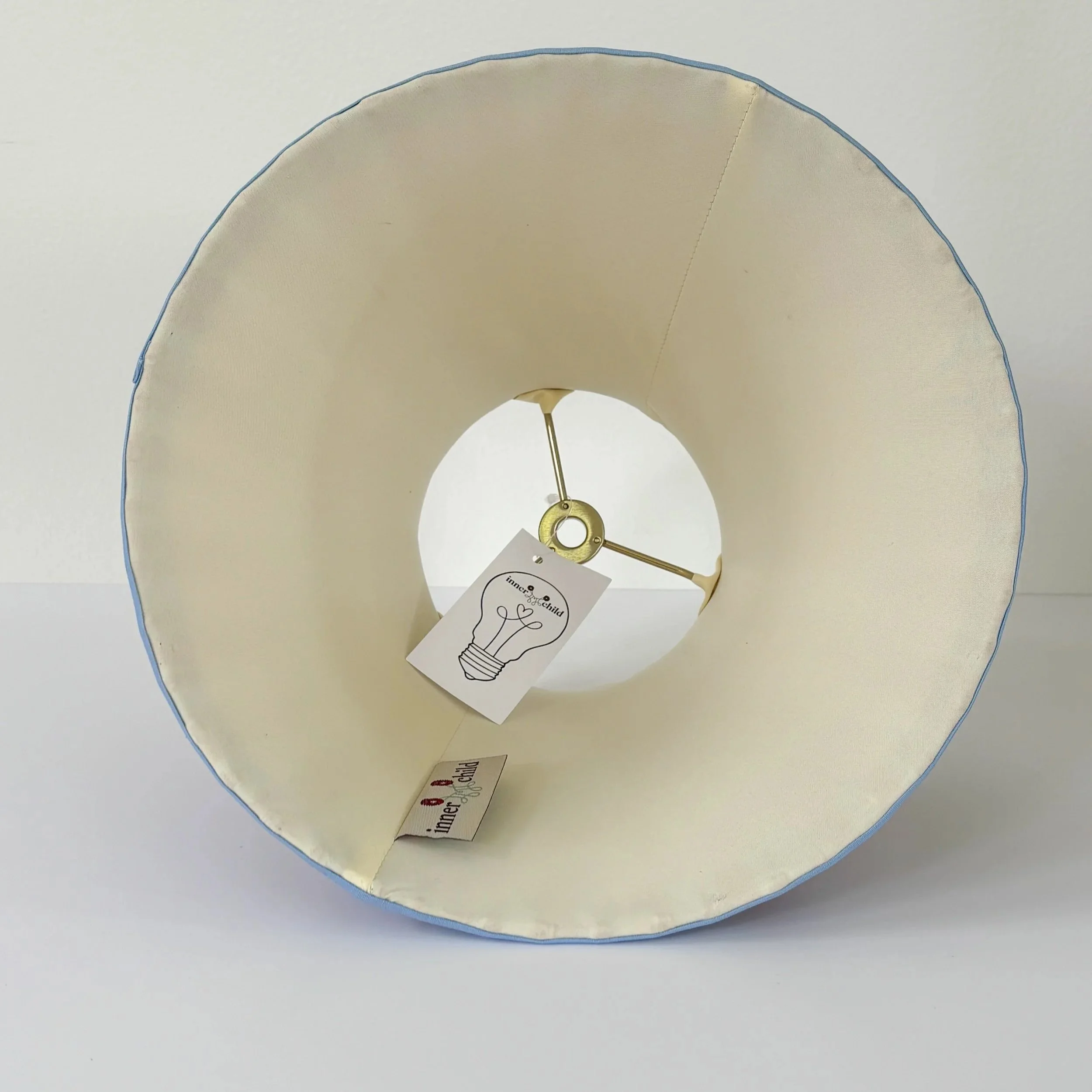 Empire lampshade with light blue trim and bold red fabric panels.