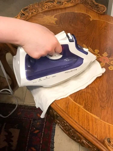 Iron over a rag on a wood table