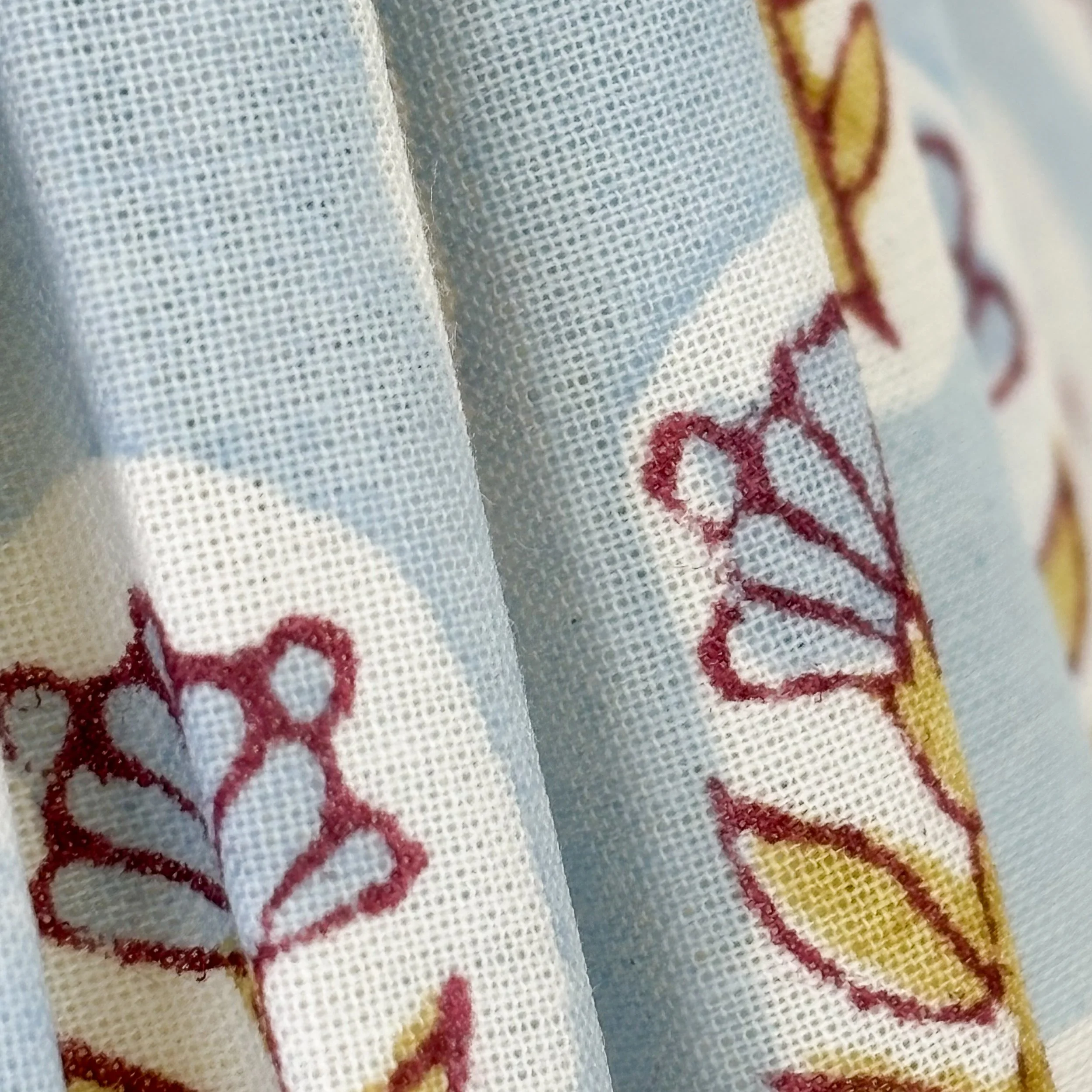 Close view of blue pleated lampshade with scalloped bottom edge