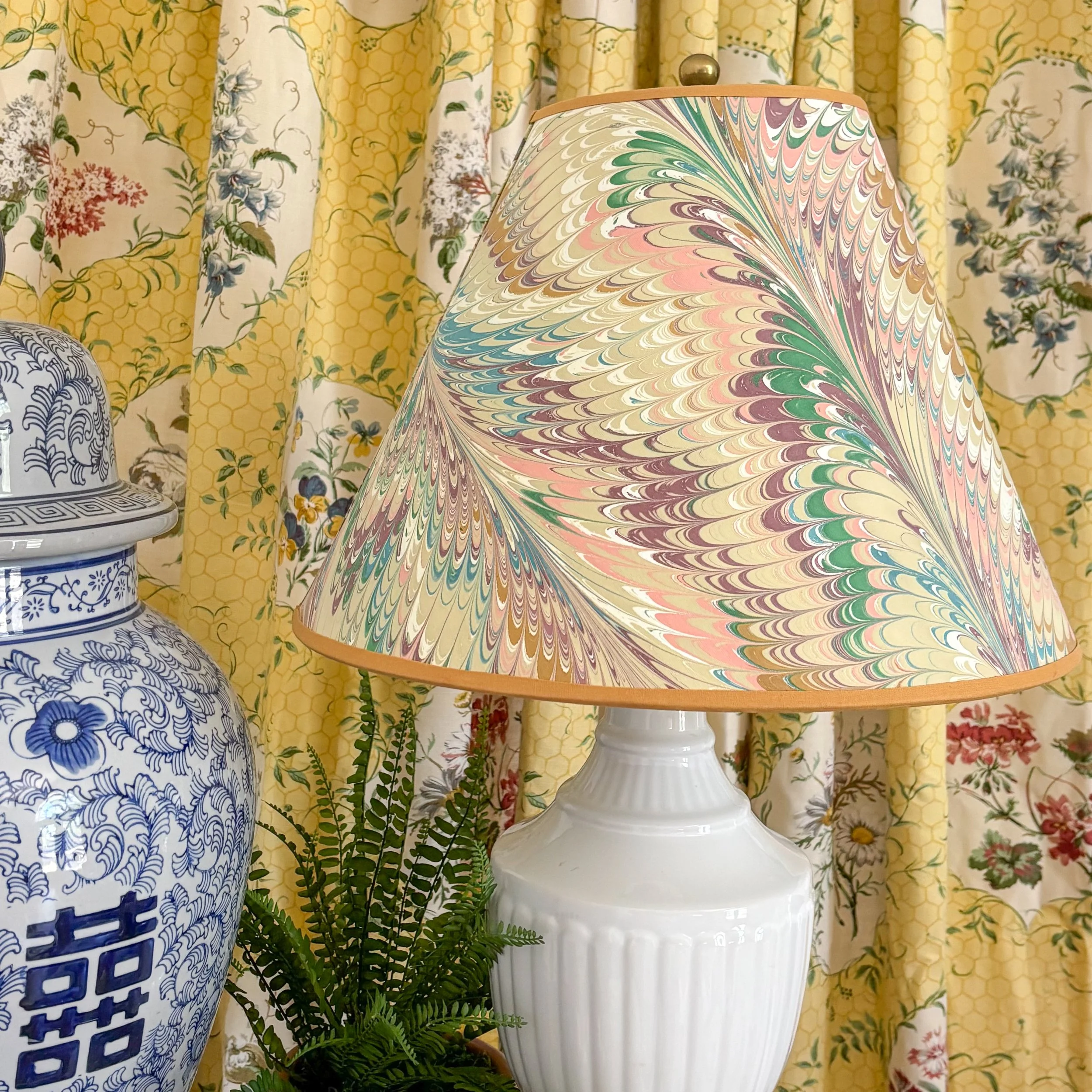 Colorful marbled lampshade styled on a table lamp, adding pattern and character to a collected home.