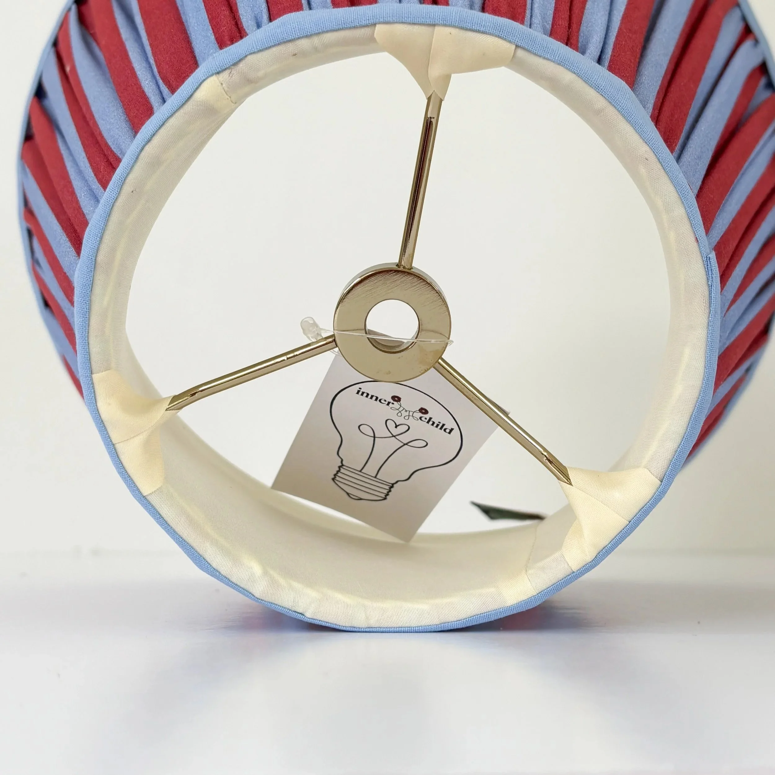 Front view of a Red and Blue Pleated Lampshade featuring alternating fabric pleats.