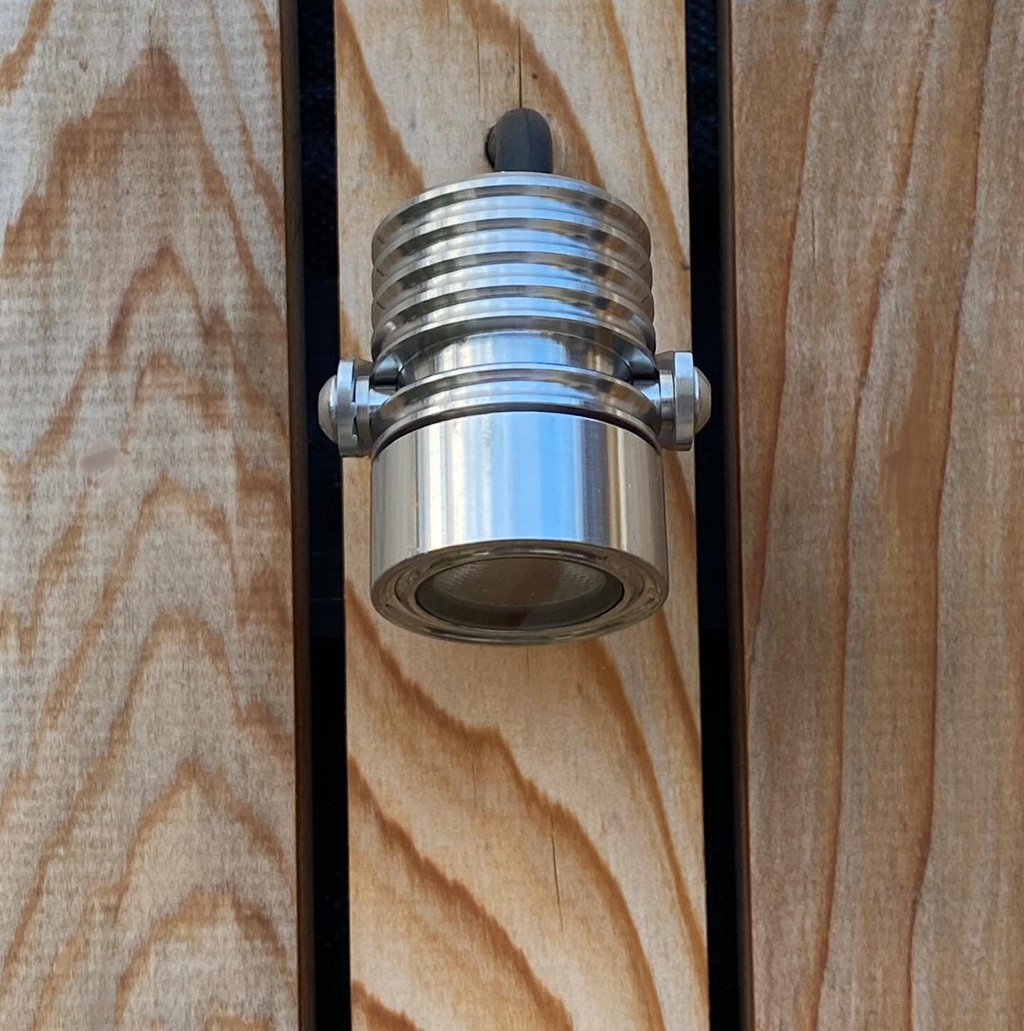 Dinky mini bracket lights on our cedar fencing. I love these wee adjustable LED spots. Really discreet at 40mm diameter they sit neatly centred on the cedar battens. 
LuxR M2 LED Bracket Spotlight in stainless steel.