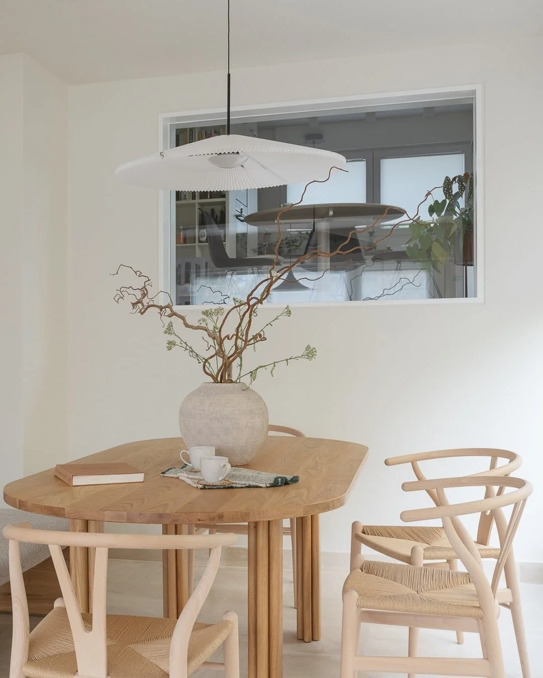 Around the table.

A dining room is used every day, so every piece has to earn its place.

The table by Studio HEMK has rounded ends and column legs. It keeps the way to the garden door clear and has no corners in anyone&rsquo;s way.

The Wishbone ch