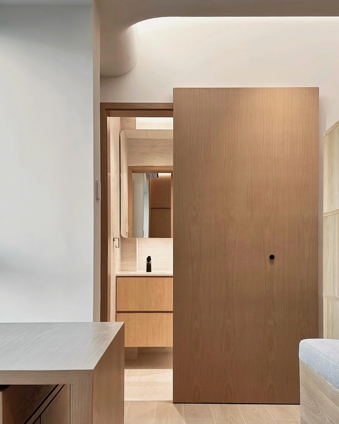 -
Residential project:
實用面積: 360sqft

《一個人的空間》

這個家的設計以簡單靈活為重點，整體用了橡木和米白色來營造出明亮又舒服的感覺。

在傢俱設計中，我們為了提高空間的流動性及配合戶主不常在家的起居習慣，我們將窗台延伸為一座可伸縮的多功能餐桌，實現「一檯三用」的功能。平日可用作為茶几，搭配兩側收納矮櫃座位，形成與友人到訪時的慵懶角落；用餐時刻，只需輕拉餐桌、展開收納的椅子瞬即轉為用餐空間。

面對天花上原有橫樑高低不一的結構，我們以弧形燈槽來過渡高低落差，
