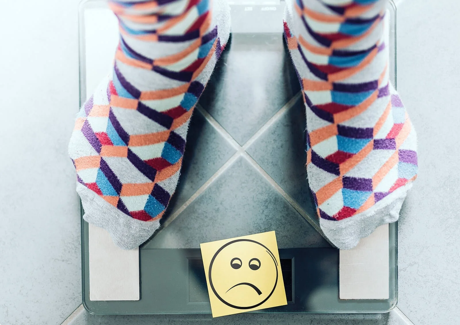 Person with multicolored socks and sticky note indicating weight dissatisfaction. We all have issues with out body,m but if these body image issues are keeping you from living its time to get help. Learn about body acceptance in Pennsylvania