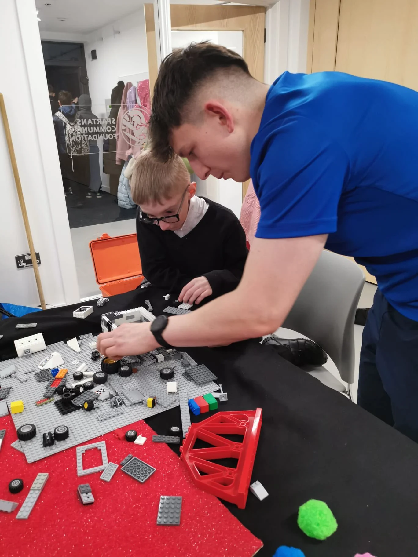 Youth worker and young person playing with lego