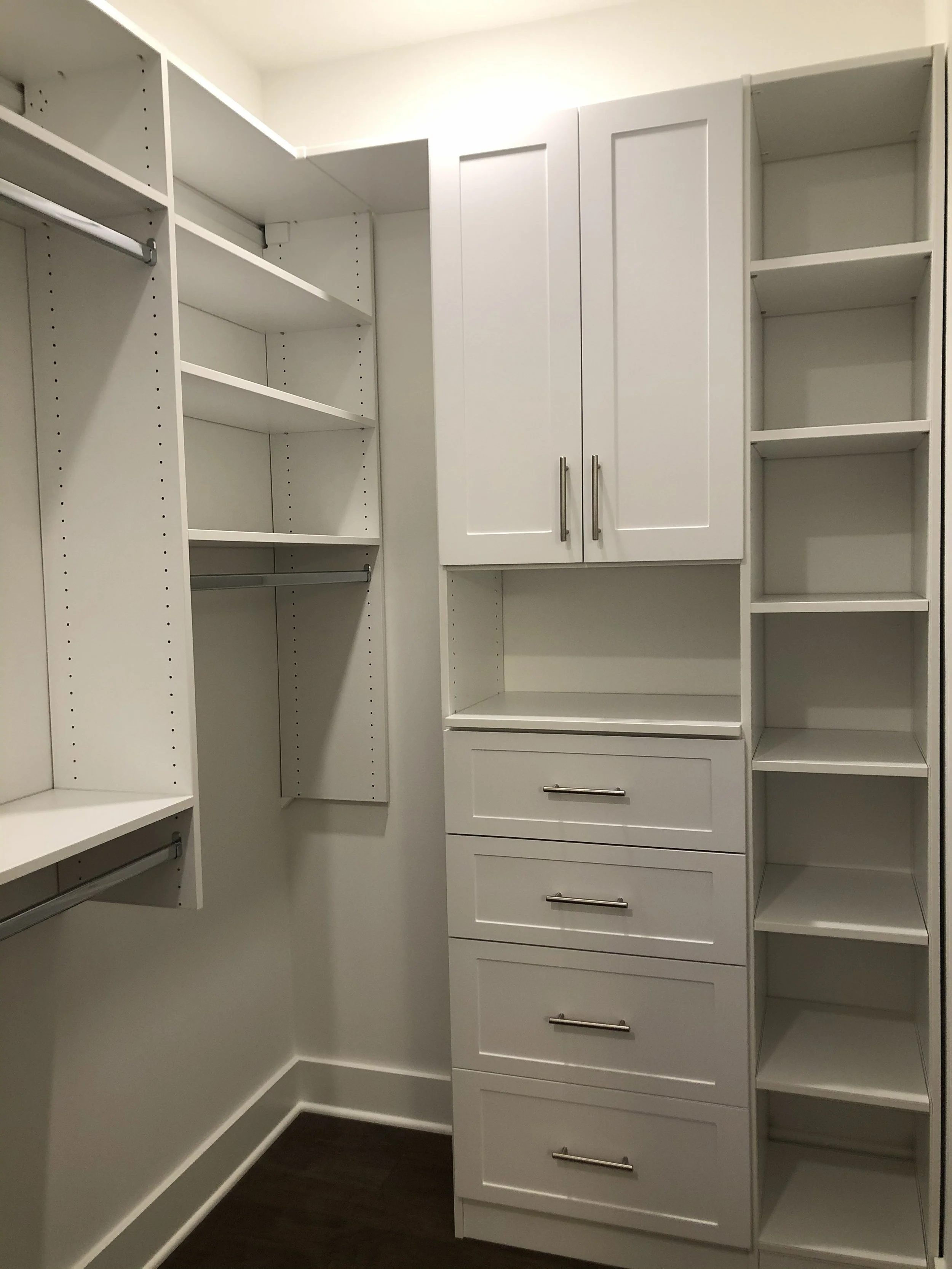 New walk-in closet with built-in shelves, drawers, and cabinets.