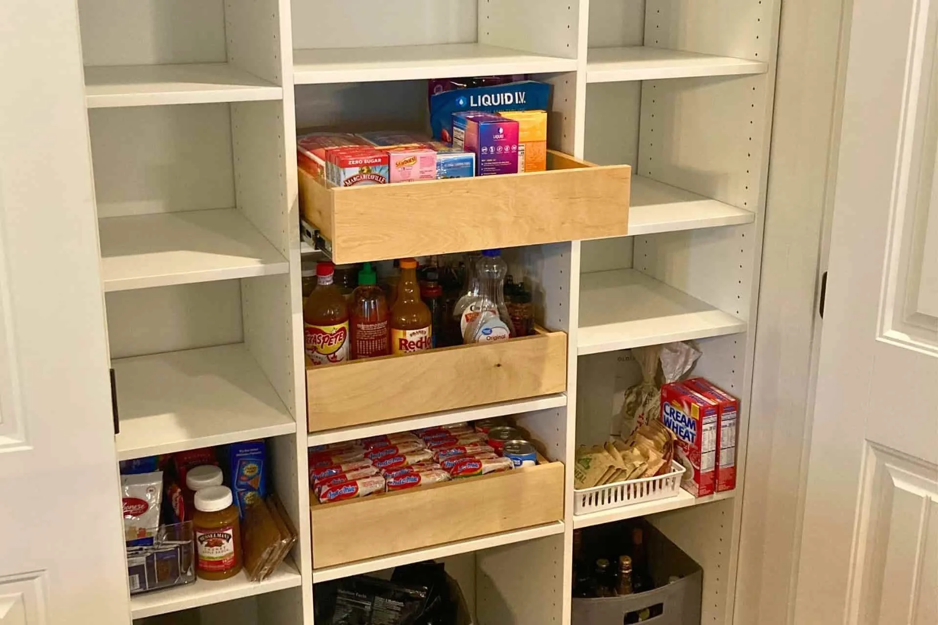 a custom kitchen pantry design featuring shelves with food and cans on it