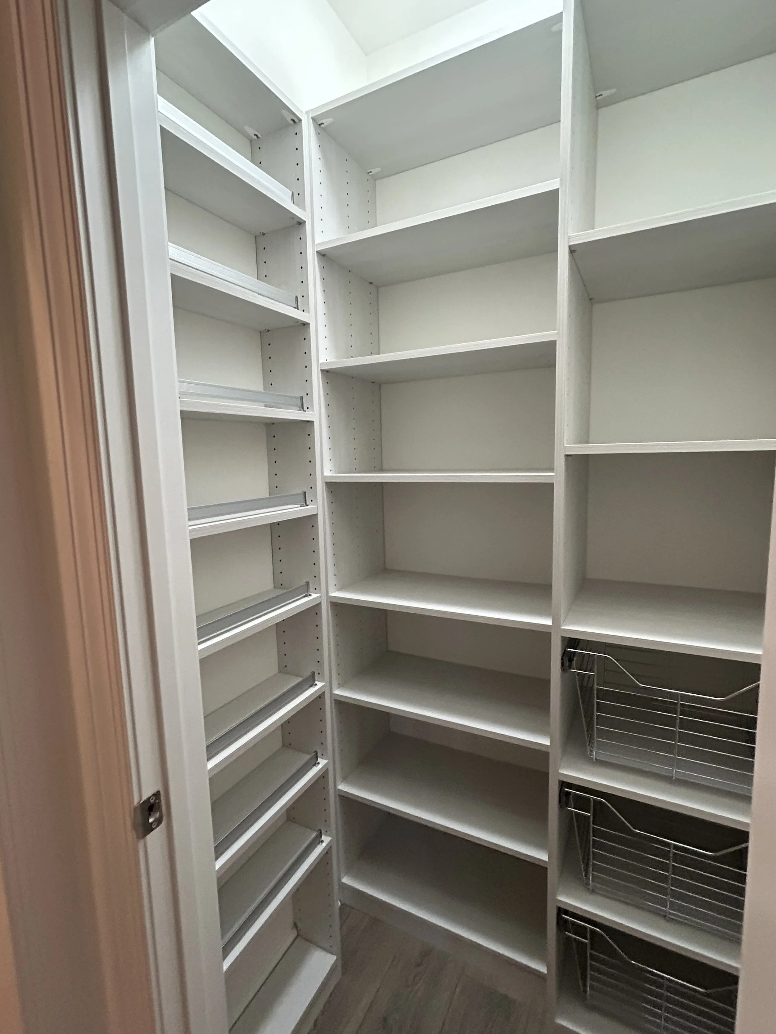 White pantry shelves with custom wire baskets on the right side.
