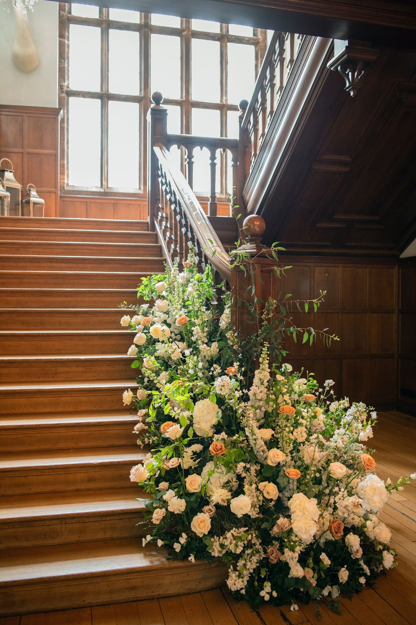 Wooden staircase with floral arrangement in a well-lit room