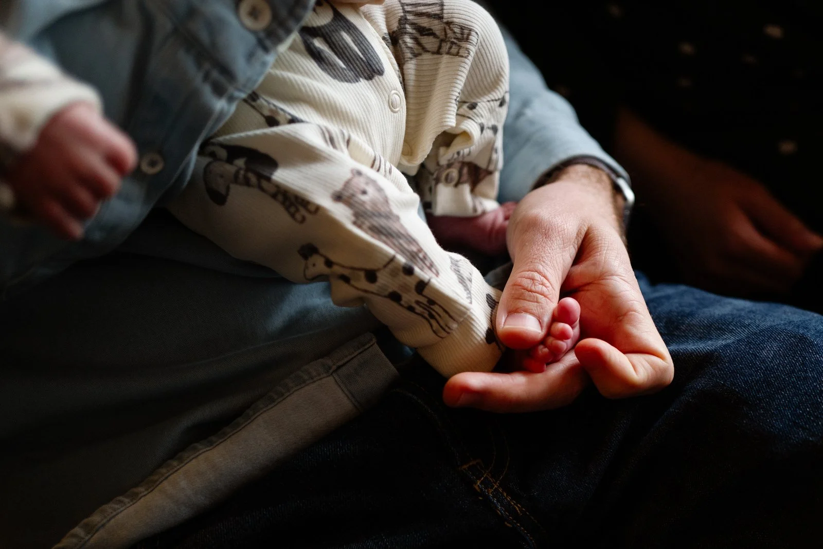 A person holding a child's tiny foot gently in their hand.