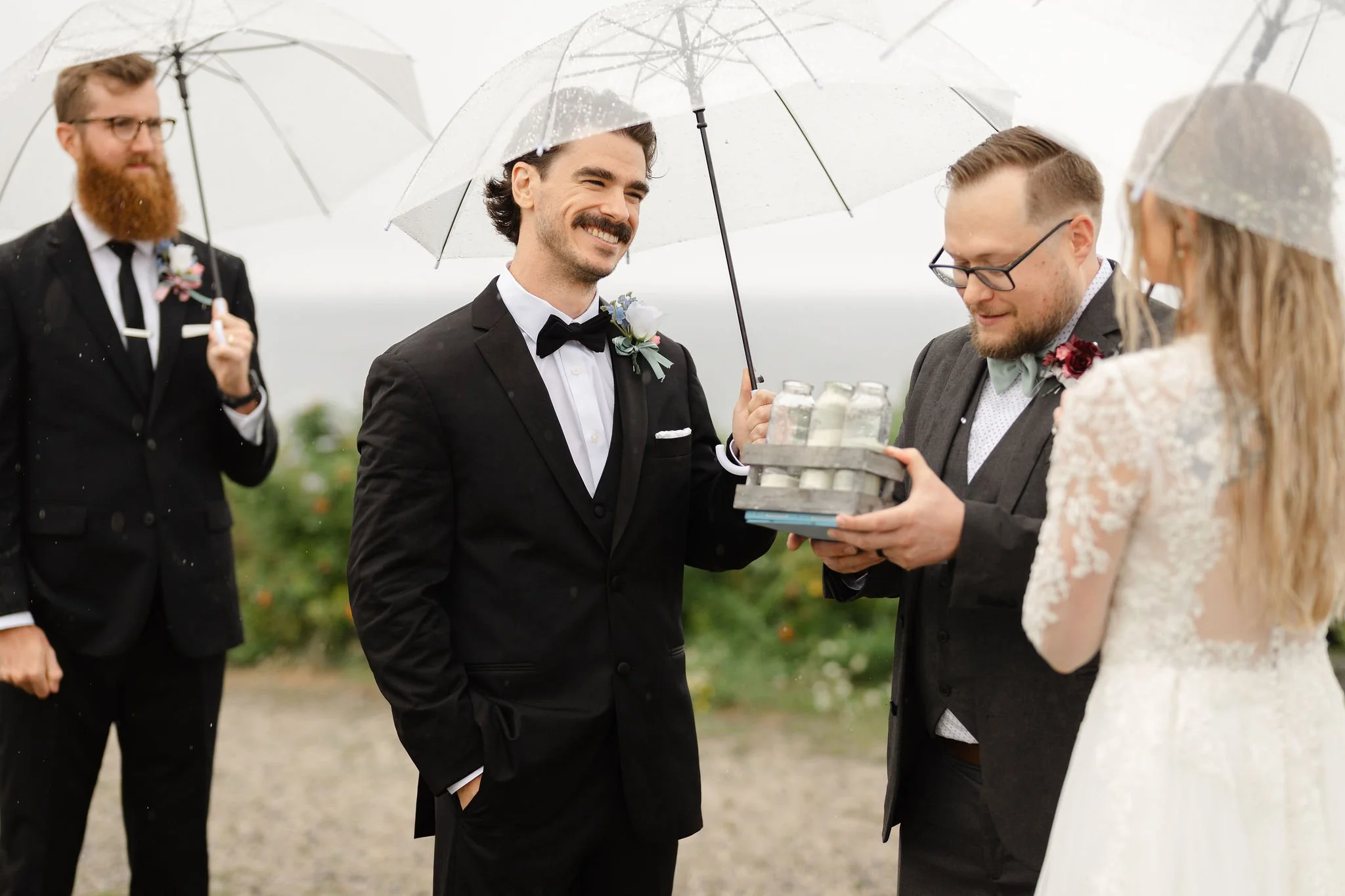 A couple appears to be at their Maine wedding, with the man in a dark suit and the woman in a white dress. They are smiling and looking at each other, captured by Maine wedding photographers Warner Photography