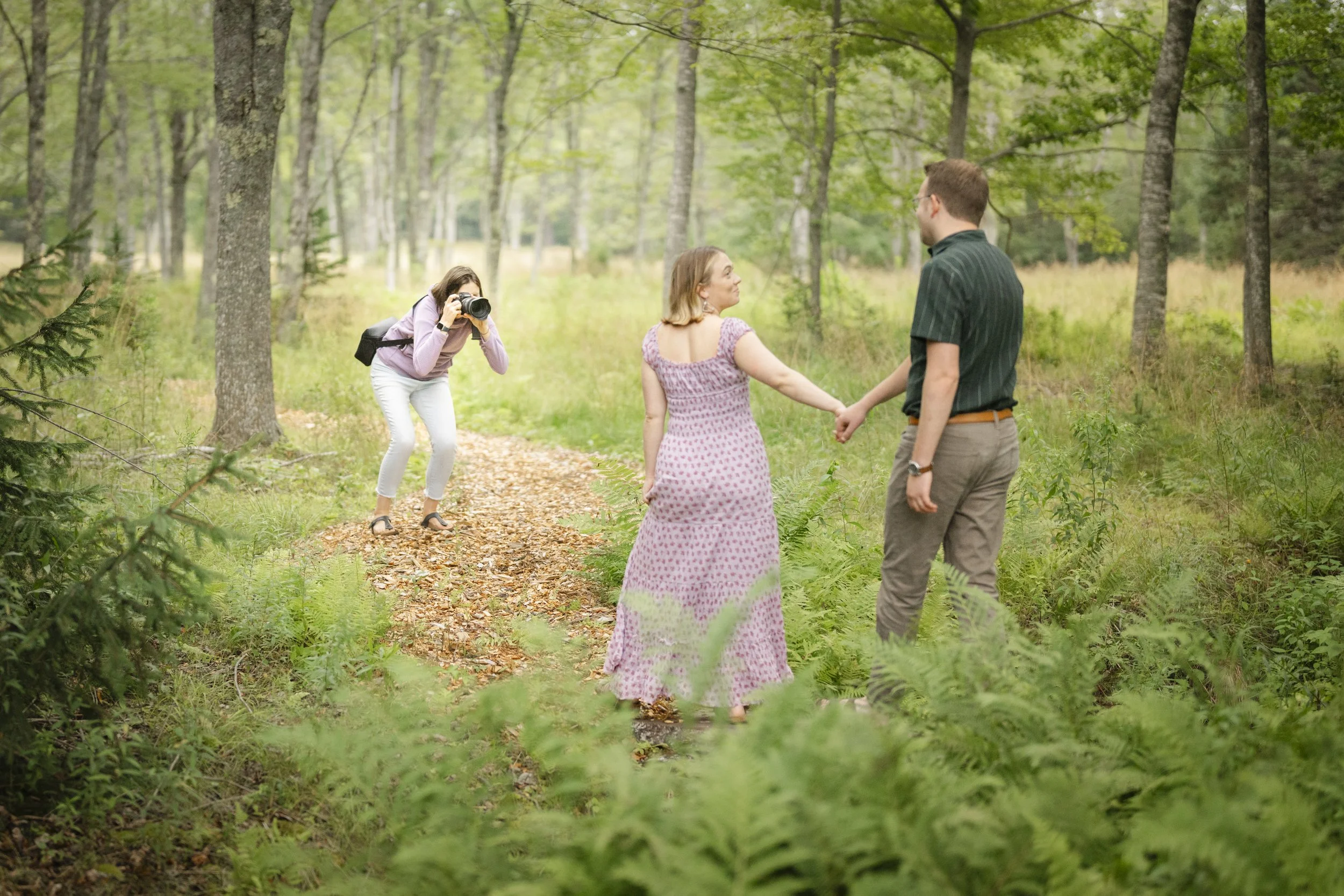A couple appears to be at their Maine wedding, with the man in a dark suit and the woman in a white dress. They are smiling and looking at each other, captured by Maine wedding photographers Warner Photography