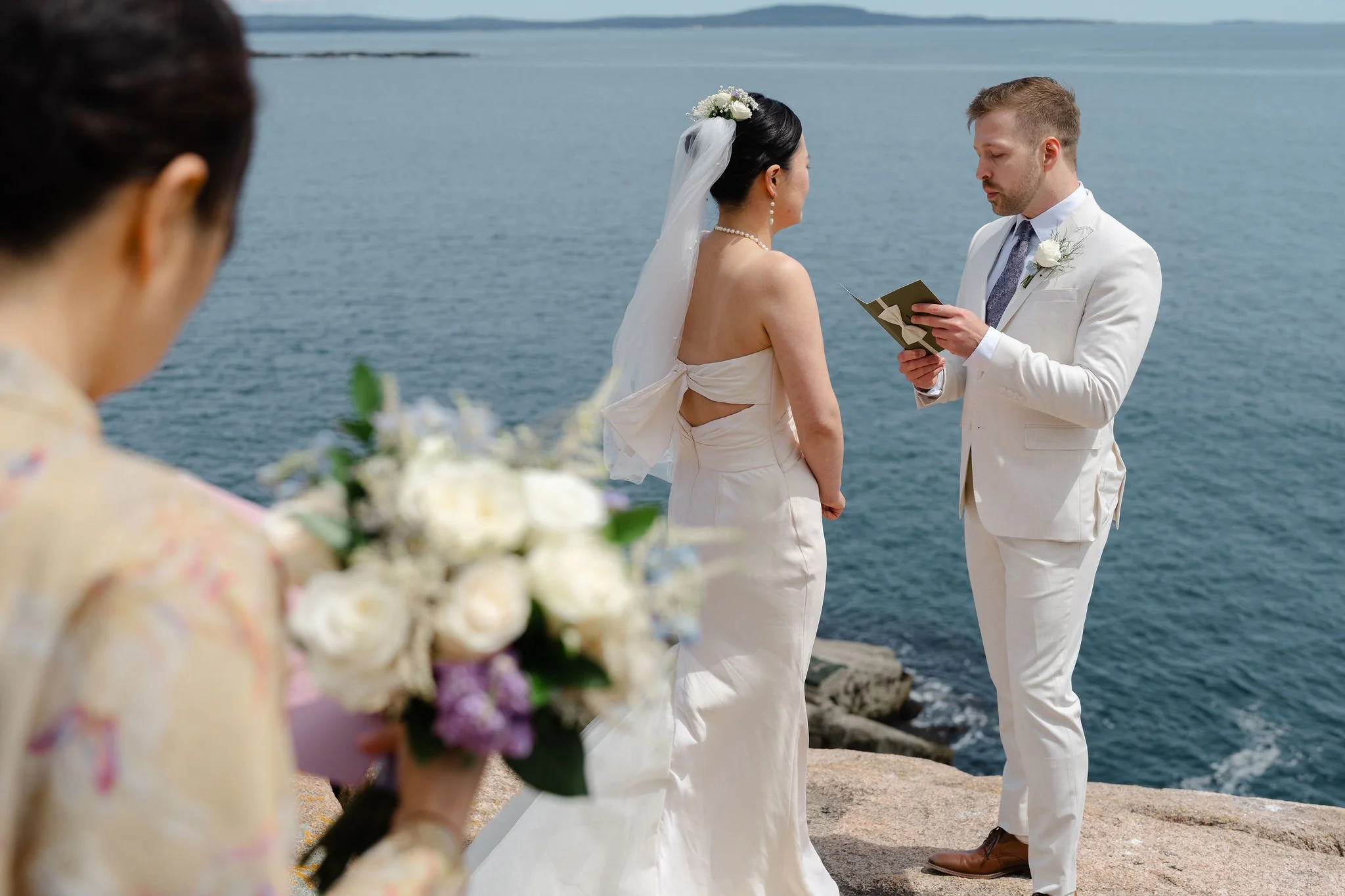 Groom reading vows during elopement in Acadia National Park photographed by Warner Photography
