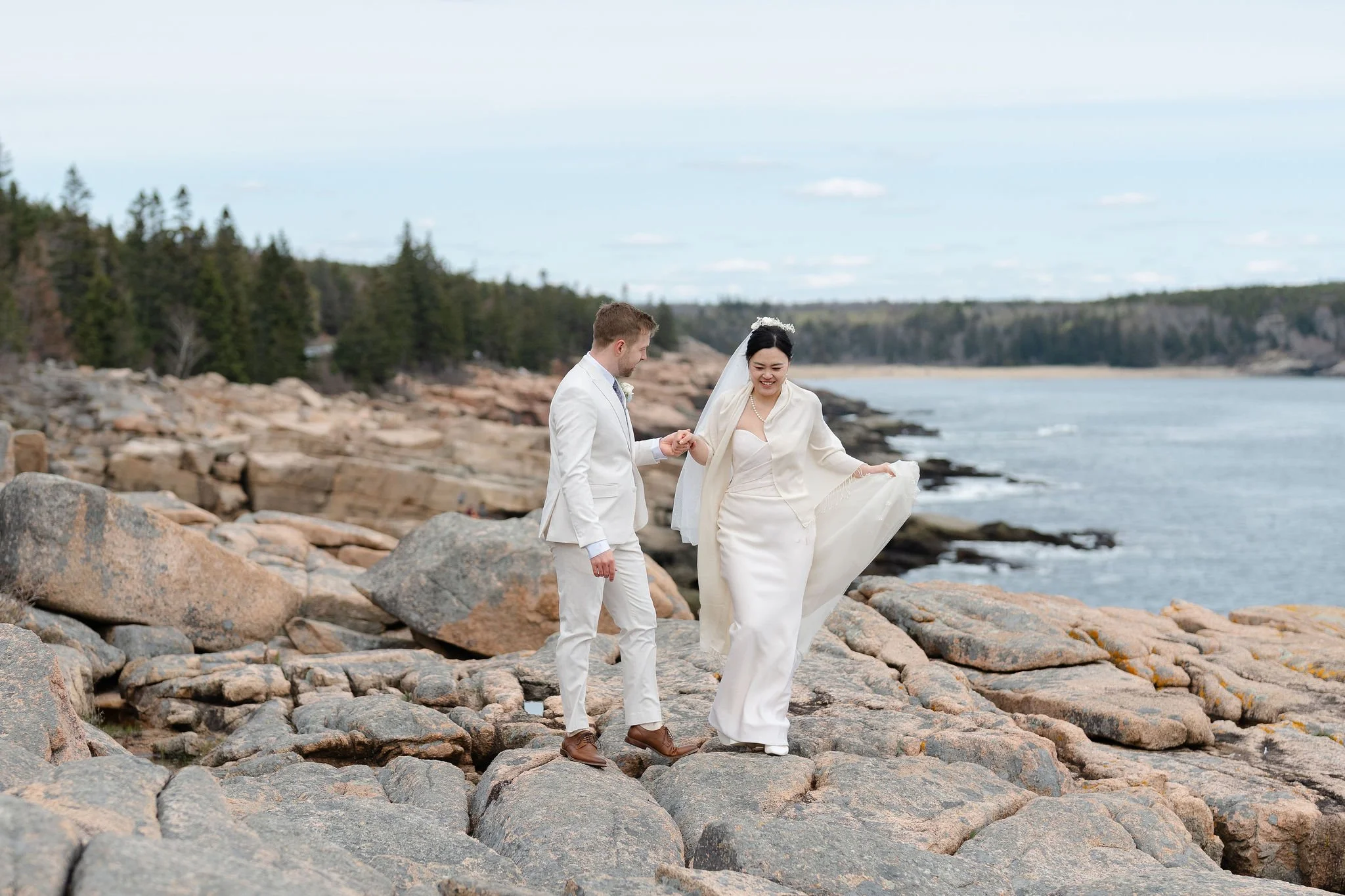 Bride and Groom walking along rocks in Acadia National Park during elopement, photographed by Warner Photography