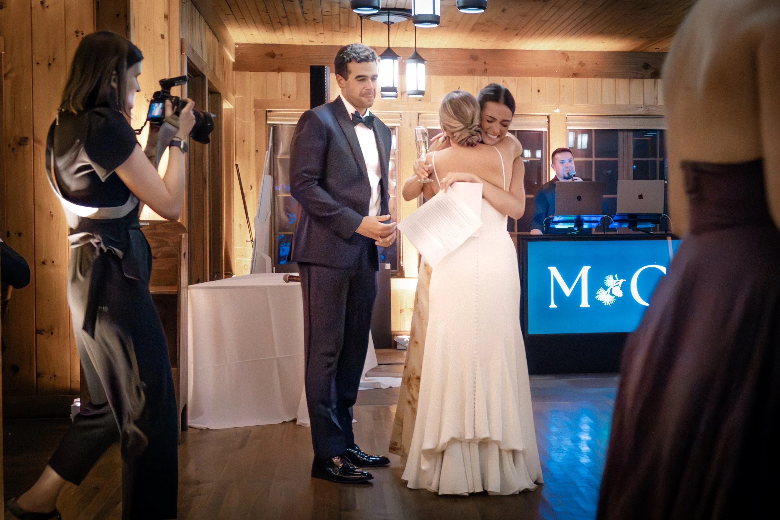 Bride and Groom hugging MOH after speech at Migis Lodge wedding in Maine