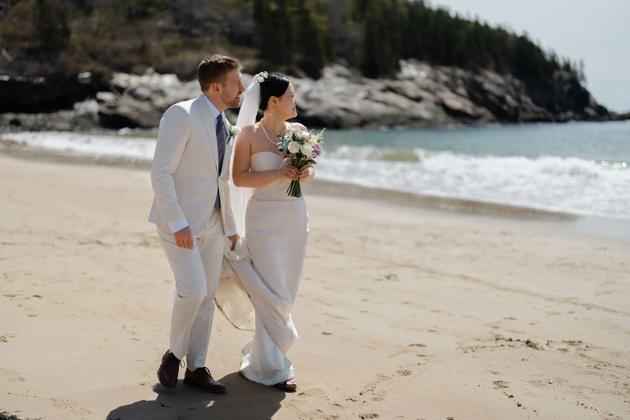 Bride and Groom walking along Sand Beach in Acadia National Park during Acadia elopement