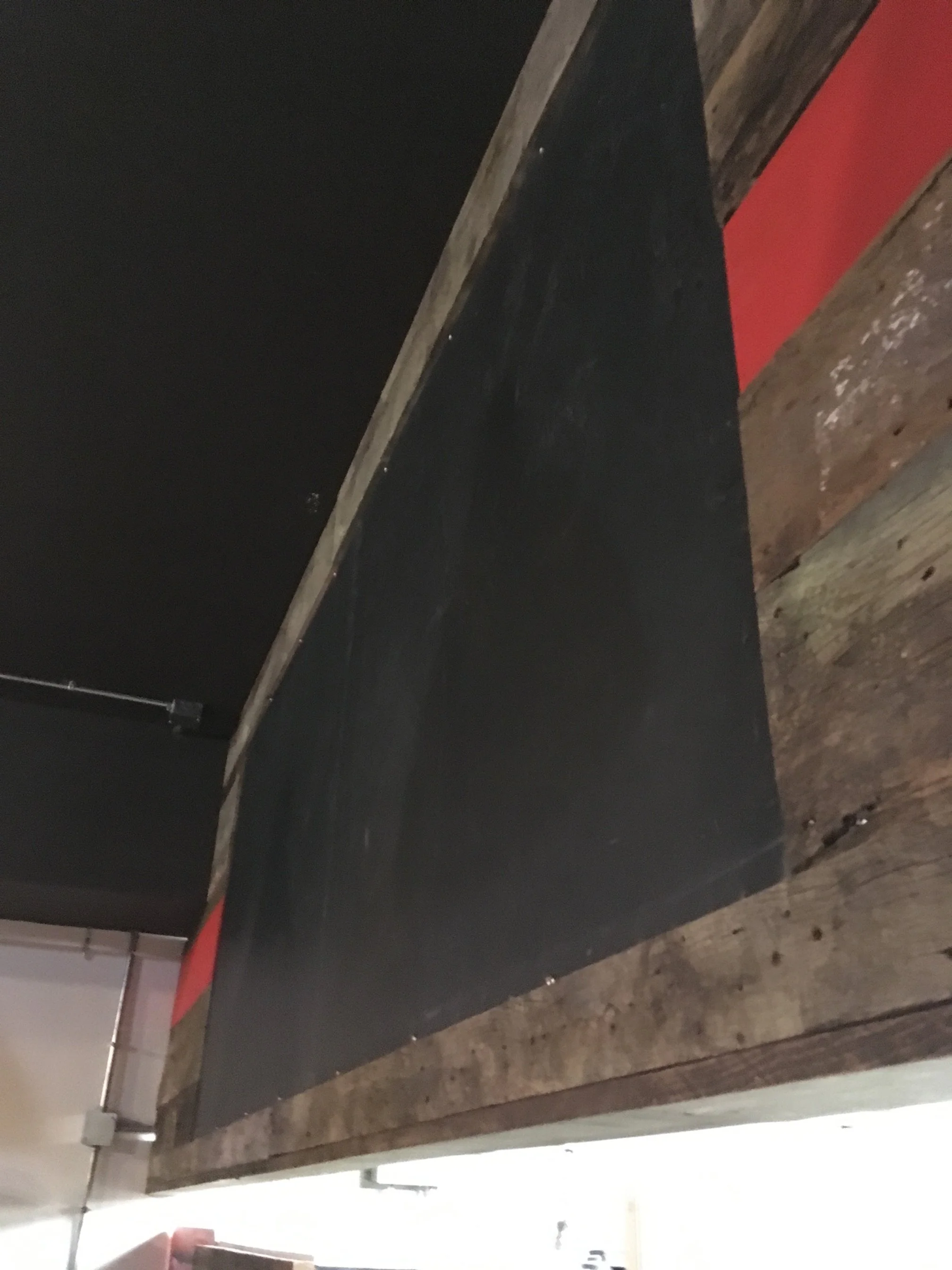 Metal chalkboard with barnboard surround.