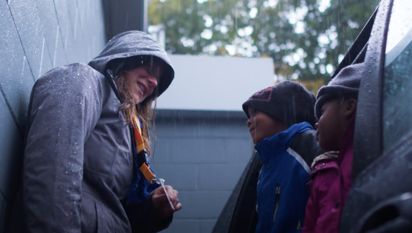a Mary's Place mobile outreach worker talks to two young Black children who are living in a minivan with their family