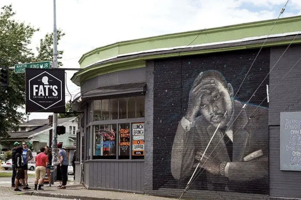 a black and white mural of Dr. Martin Luther King Jr. painted on the side of a building in Seattle's Central District