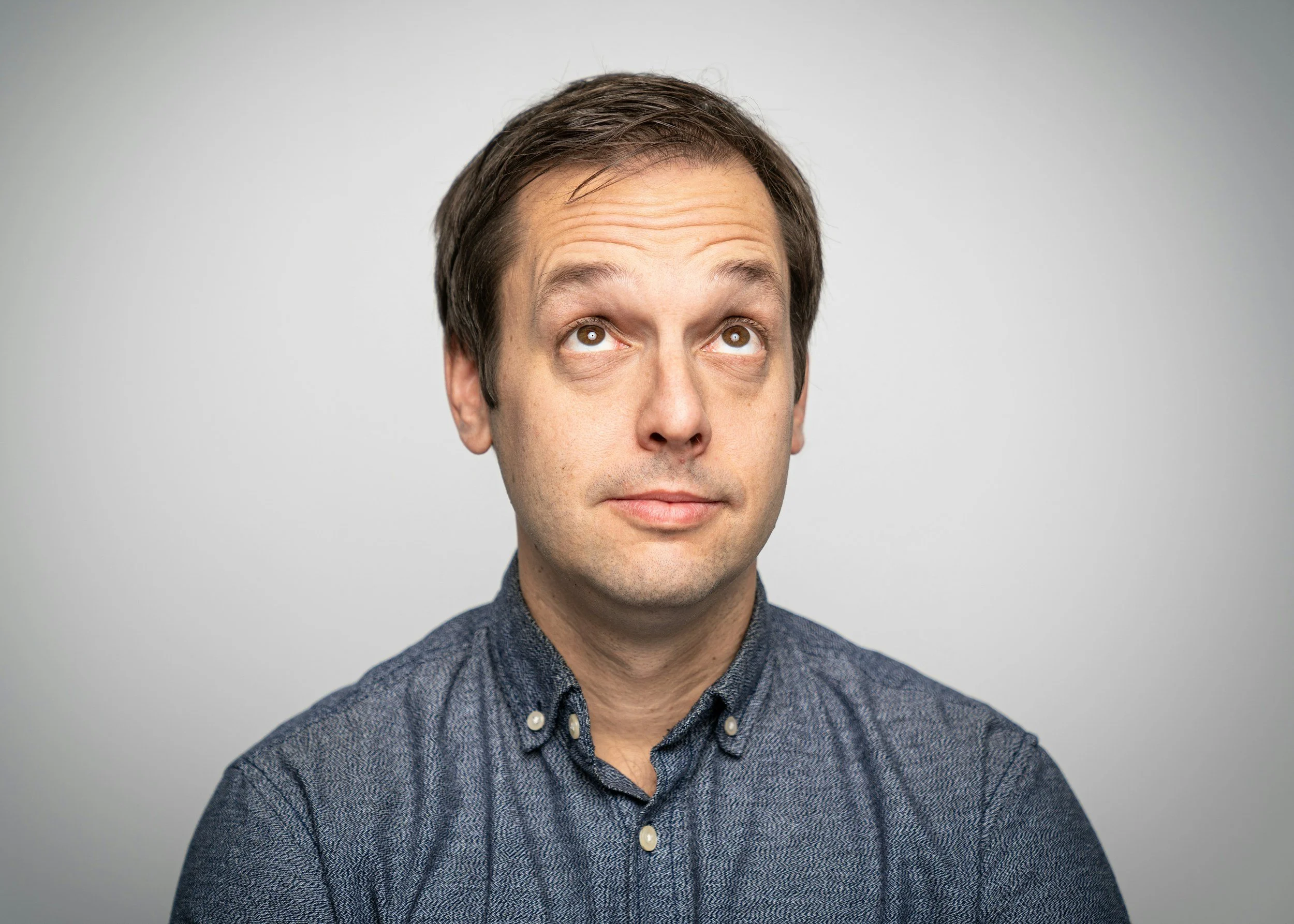 Man in a reflective pose looking upward illustrating contemplation and understanding of intrusive thoughts in OCD awareness