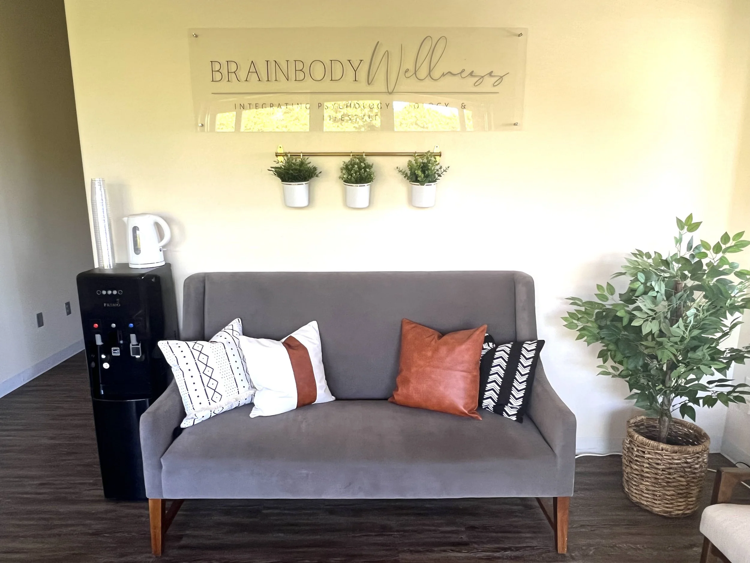 The lounge area of BrainBody Wellness Counseling, featuring a warm and inviting space with comfortable seating, soft lighting, and a calming atmosphere designed to help clients feel relaxed and welcome.