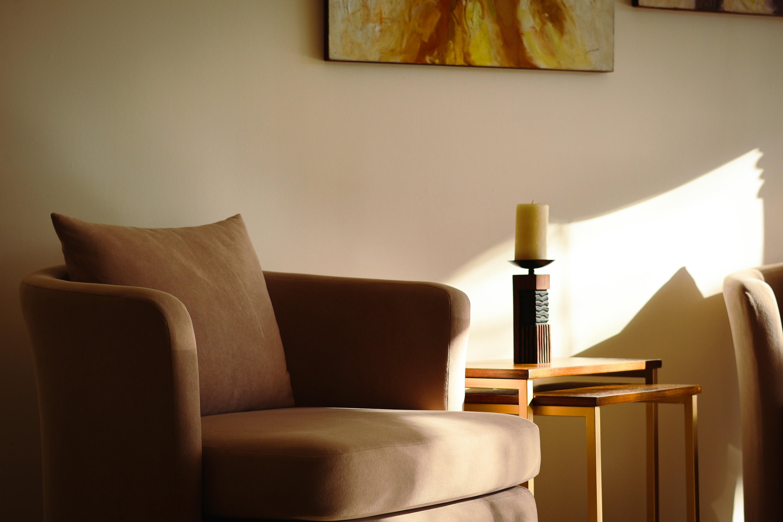 Comfortable upholstered sofa chair in a counseling office in Arizona, designed for therapy sessions, with soft lighting and a calming mental health wellness environment supporting counseling in Arizona.