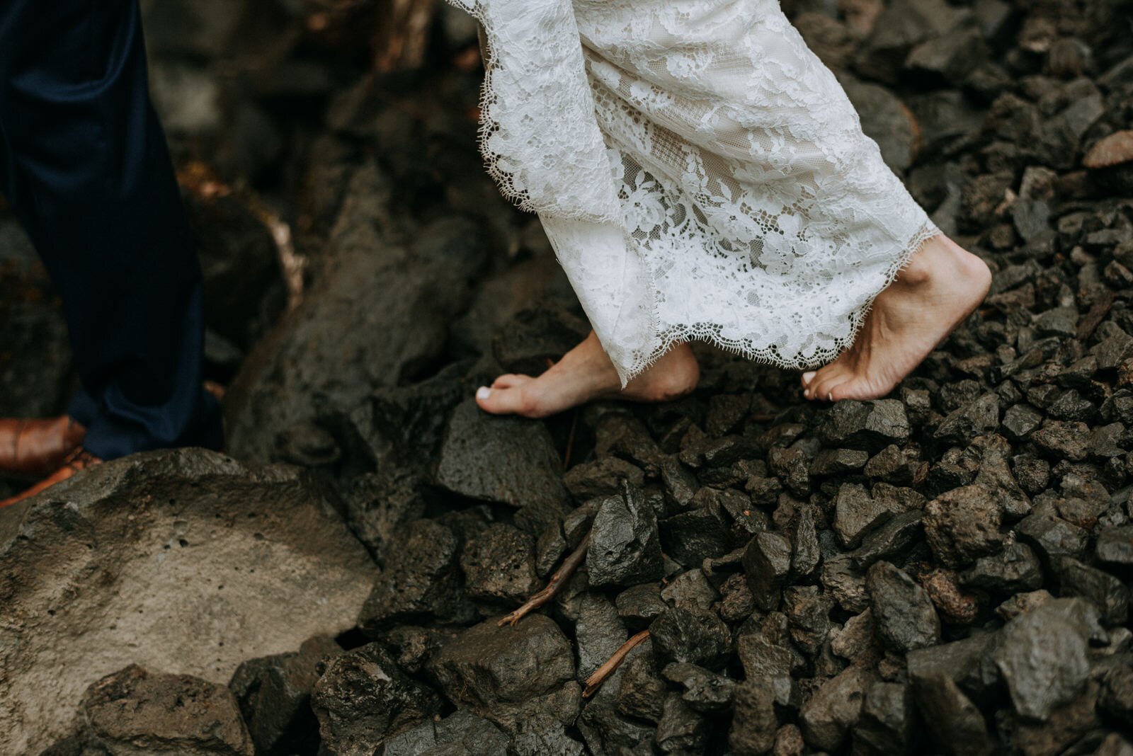 barefoot bride walking along rocks