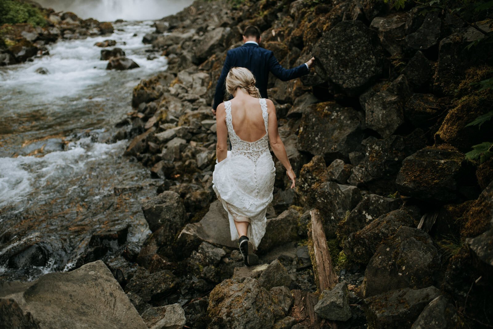 bride and groom hiking in wedding clothes