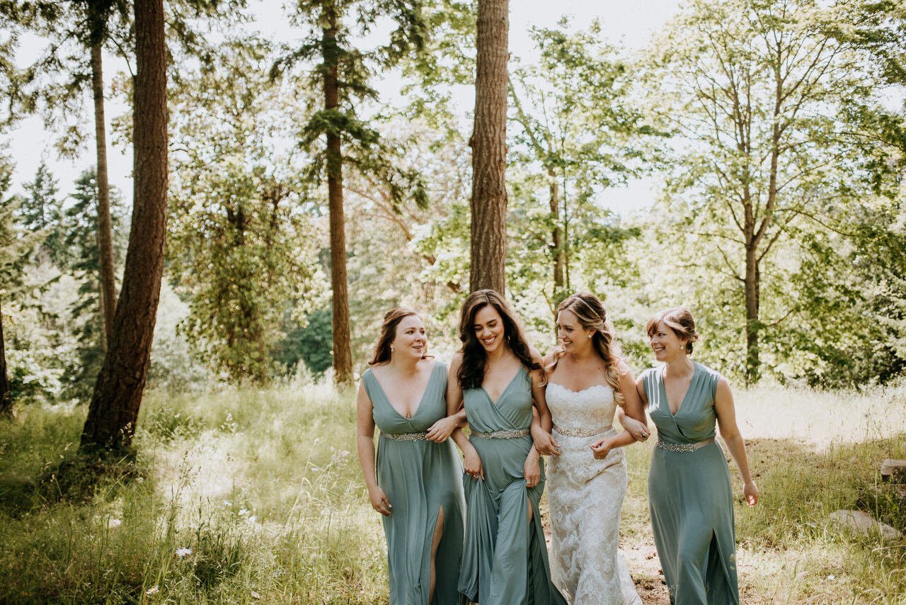 candid bride and bridesmaid portrait walking in forest