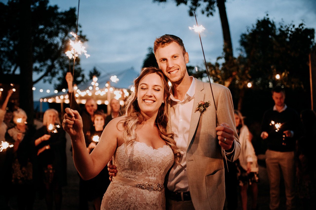 happy wedding couple holding sparklers at bodega ridge wedding
