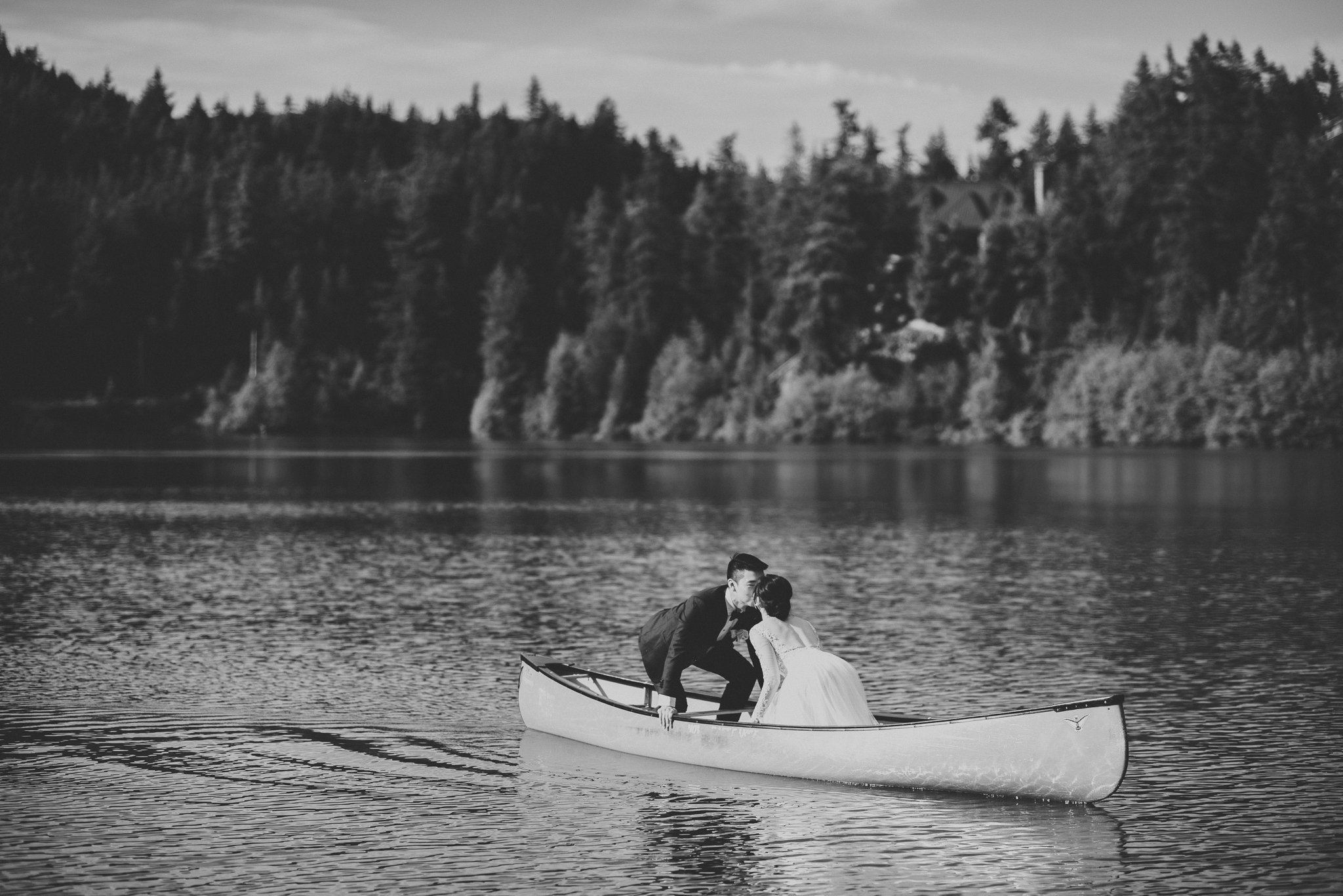 Bride and groom kiss canoe