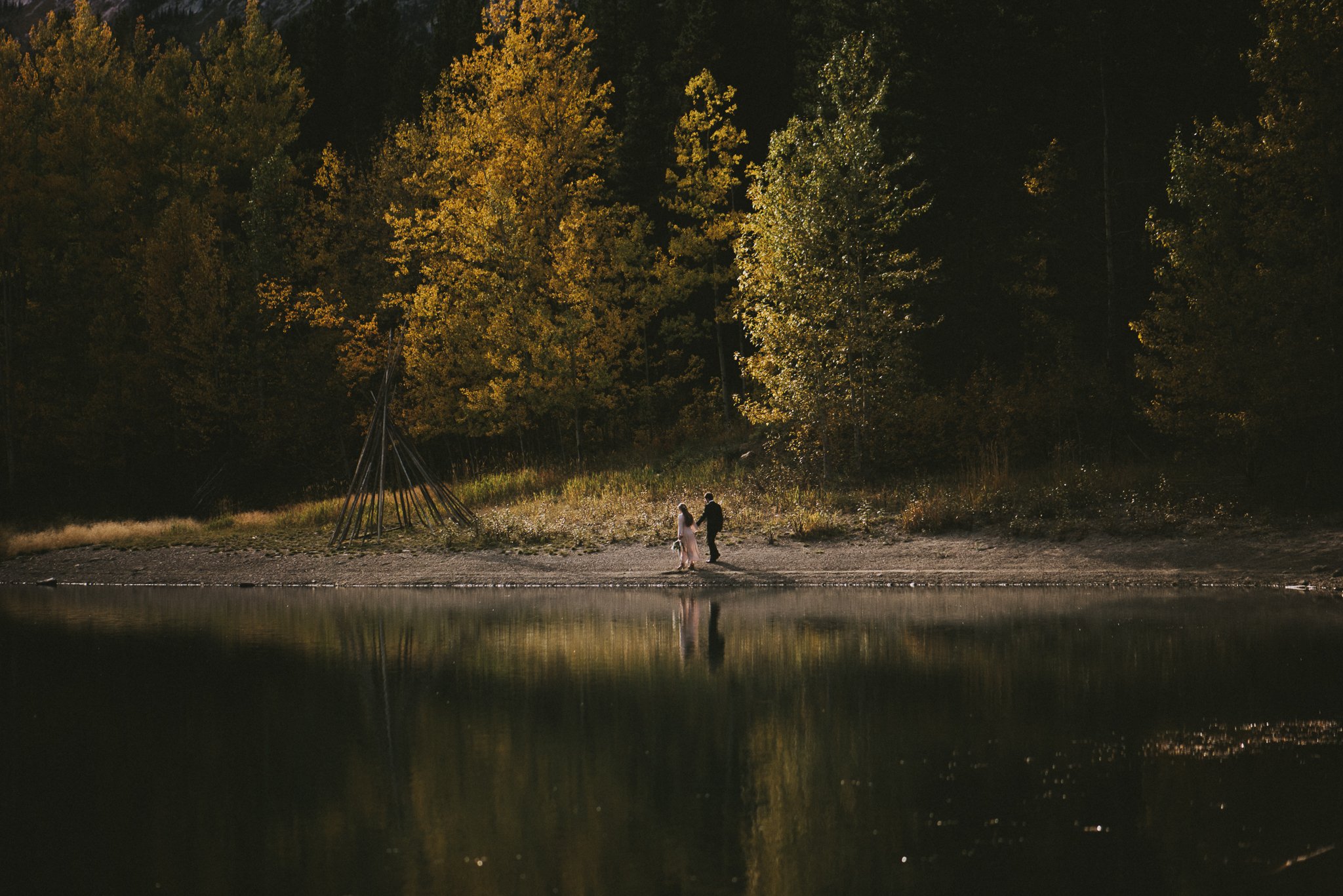 bride groom by water reflection forest elopement kananaskis